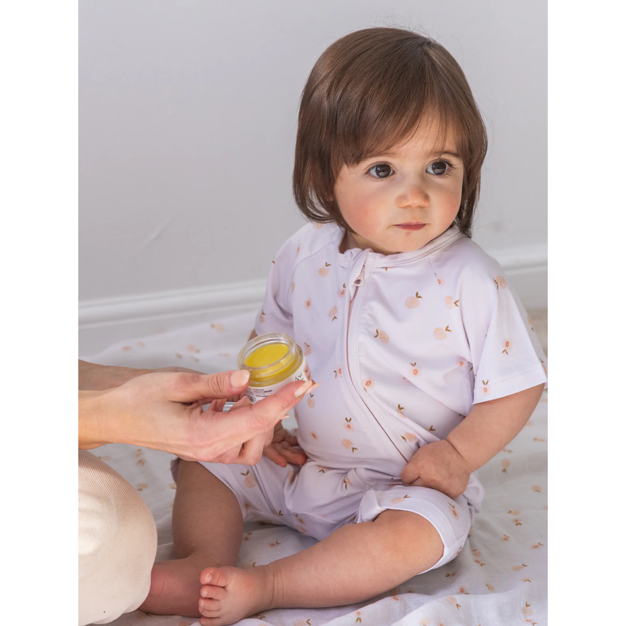 אוברול קצר עם רוכסן - צבע לבן מעוטר באפרסקים