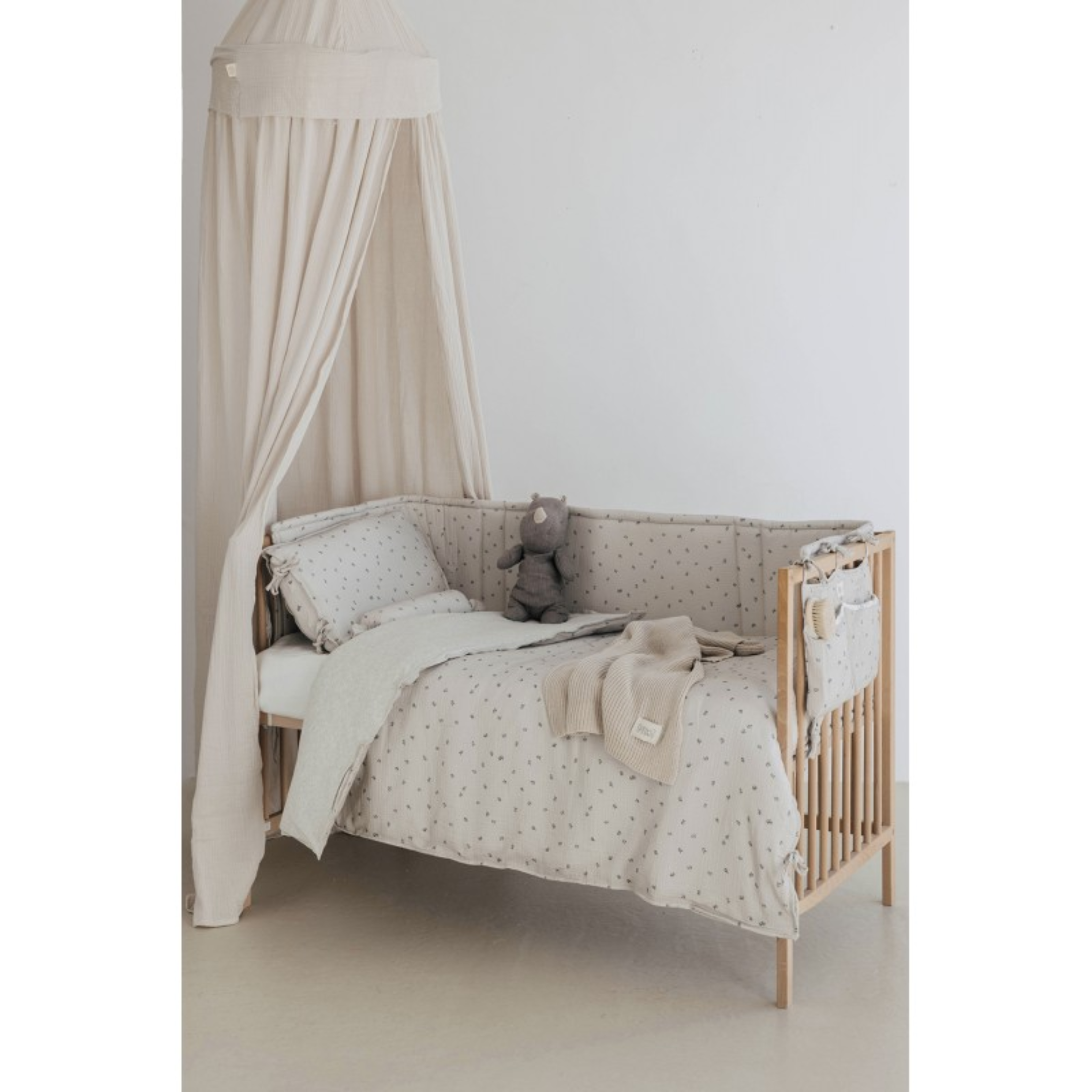 ארגונית למיטת תינוק מכותנה אורגנית - בצבע אפור בהיר מעוטרת במשמשים